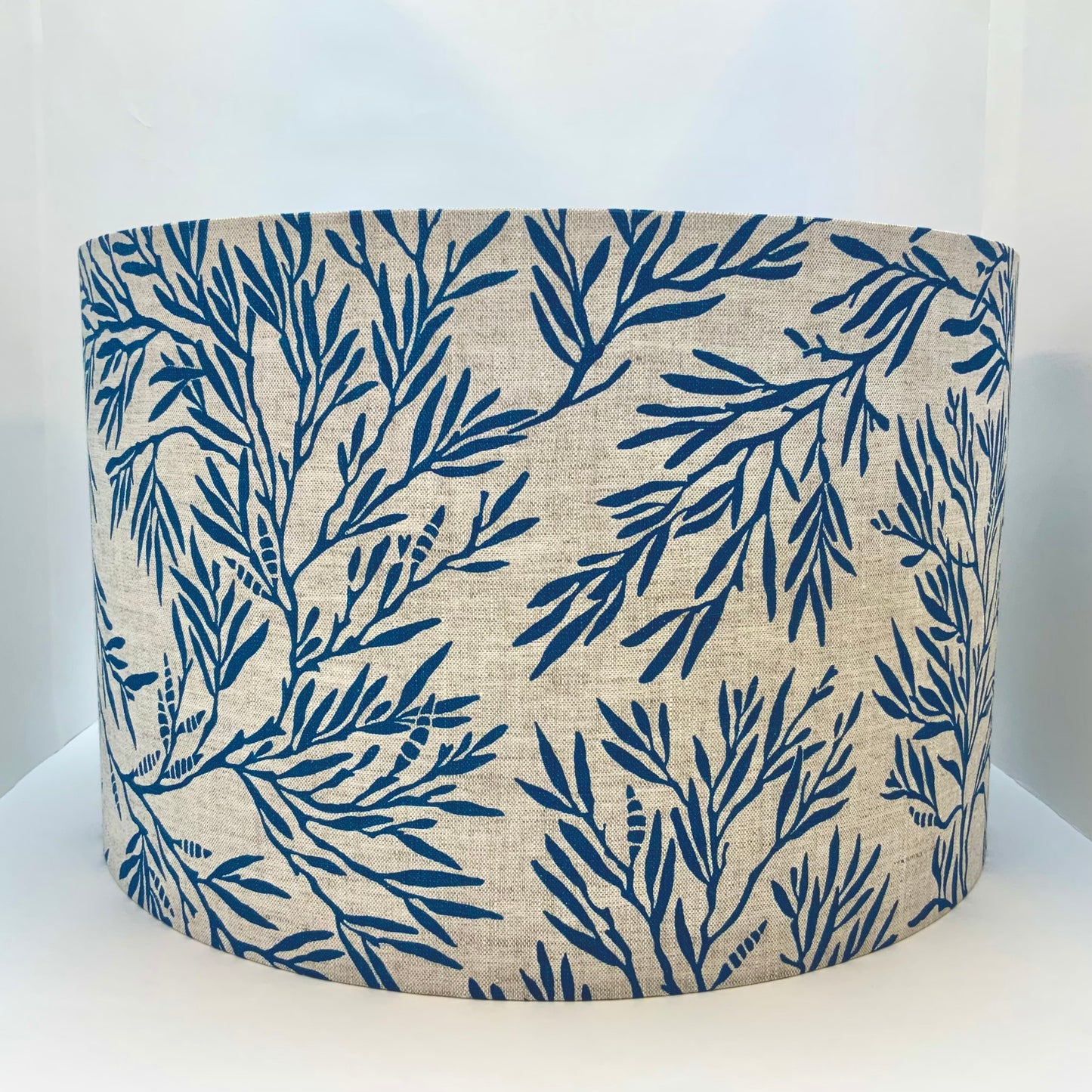 Handprinted linen lampshade in ink blue with a seaweed pattern.